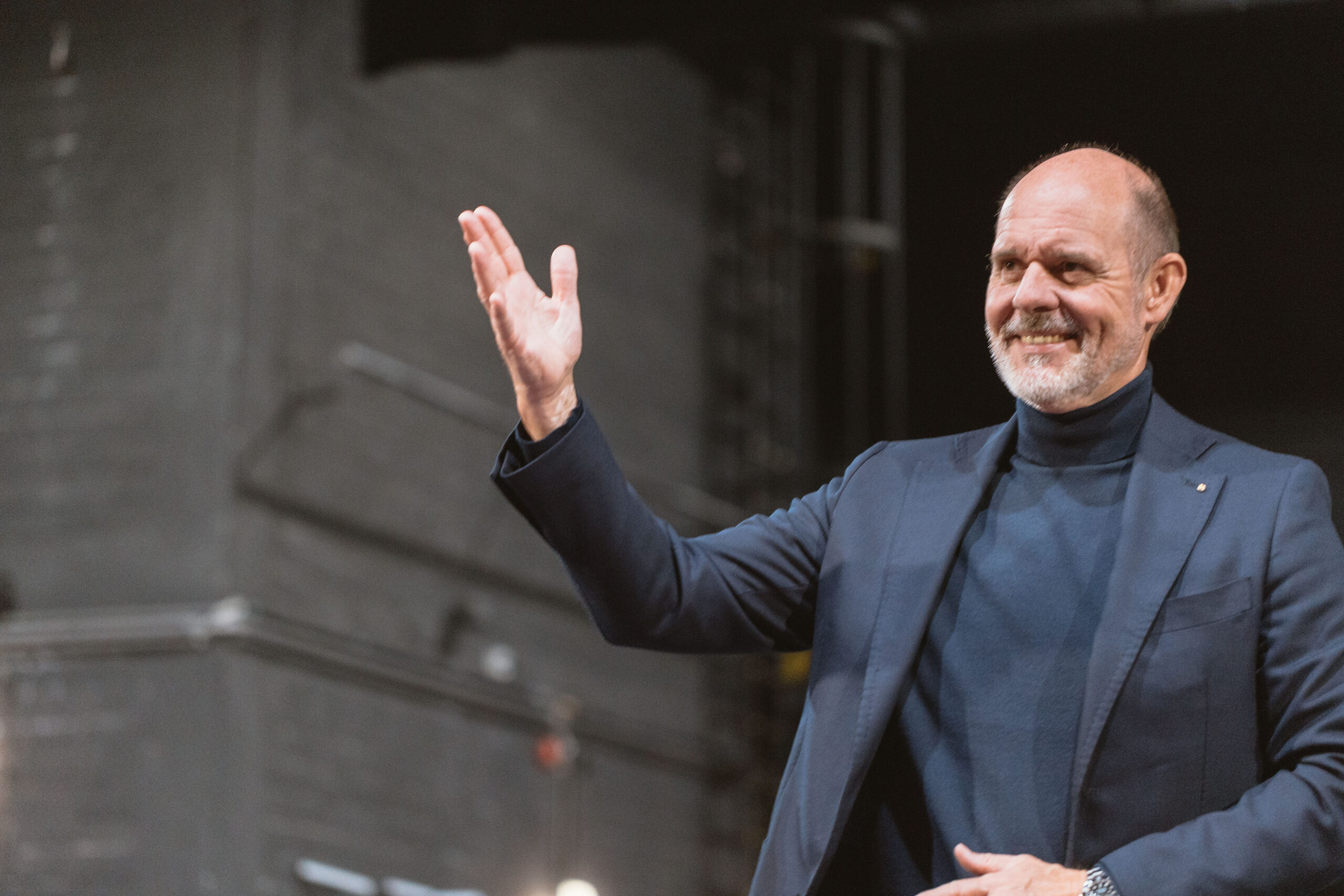 Michael Bümmerstede steht auf einer Bühne und tritt als Speaker auf