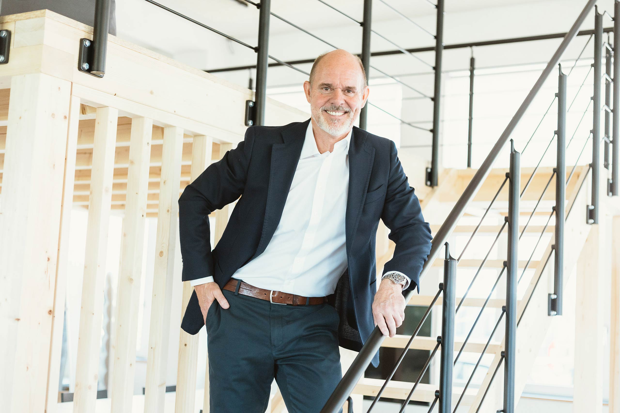 Michael Bümmerstede steht in einem Verantstaltungsraum auf einer Treppe.